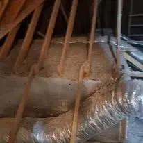 Spray foam insulation filling the roofline of an unfinished attic